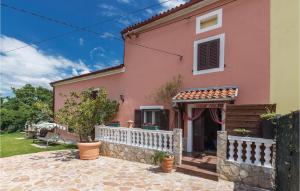 une maison rose avec une clôture blanche dans l'établissement 2 Bedroom Stunning Home In Pula, à Pinezići