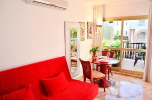 マルベーリャにあるRomana Playa Marbellaのリビングルーム(赤いソファ、テーブル付)