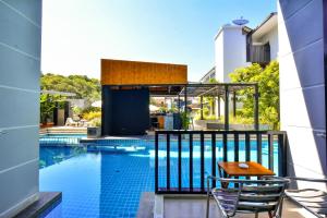 a swimming pool with two chairs and a table on a balcony at Aonang Viva Resort - SHA Plus in Ao Nang Beach