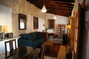 een woonkamer met een blauwe bank en een tafel bij Casa de la Fra in Jerez de la Frontera