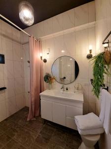 a bathroom with a sink and a mirror and a toilet at Chi Mei Homestay in Green Island