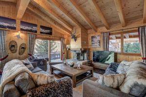 - un salon avec des canapés et une télévision dans une cabine dans l'établissement Chalet le Grand Ours, à La Tzoumaz