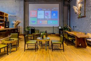 un grande schermo in una stanza con tavoli e sedie di Guilin Changshe Hotel a Guilin