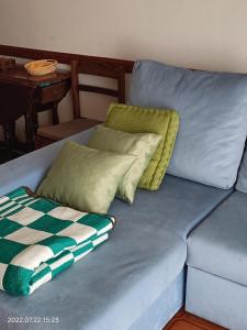 Un sofá azul con dos almohadas. en Apartamento Praia da Torreira, en Torreira