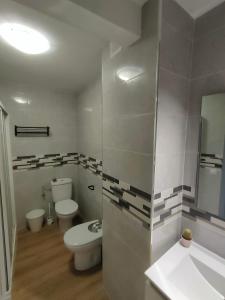 W łazience znajduje się toaleta, umywalka i lustro. w obiekcie CASA GLORIA w mieście Ganuza