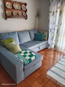 a living room with a blue couch in a room at Apartamento Praia da Torreira in Torreira
