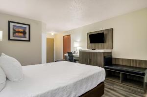 Habitación de hotel con cama, escritorio y TV. en Rodeway Inn Enumclaw Mount Rainer-Crystal Mountain Area, en Enumclaw