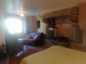 a room with a living room with a couch and a fireplace at Frairie Du Divit in Pontivy