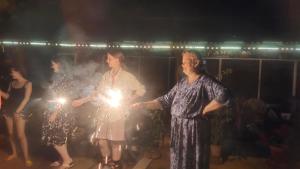 a group of women holding lights in their hands at Ambadi's villa -Lake view resort in Pallipuram