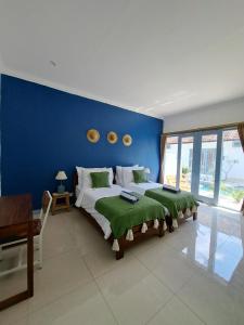 Kubuwatu Boutique Accommodation في غيلي تراوانغان: غرفة نوم بسرير كبير بجدار ازرق