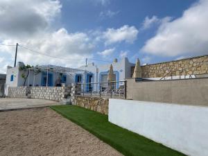 Villa Otos في Afiartis: منزل بأبواب زرقاء وجدار حجري