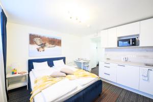 1 dormitorio con 1 cama grande y cocina en Stay to Stay Apartments - võtmeta sissepääs, en Tartu