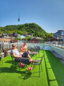 two people sitting on the roof of a building at Namsan Guesthouse in Seoul