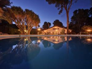 - une piscine avec une maison et des arbres la nuit dans l'établissement Finca la Yuca, à Ontinyent