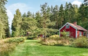 a red barn in the middle of a field at Pet Friendly Home In Boxholm With Kitchen in Blåvik