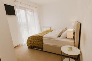 Schlafzimmer mit einem Bett, einem Tisch und einem TV in der Unterkunft Hill View Apartment Tatragolf in Veľká Lomnica
