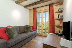 a living room with a couch and a tv at Chalet Grand Roi in La Tzoumaz