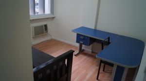 Habitación pequeña con escritorio azul y mesa. en Technologic Apart en San Miguel de Tucumán