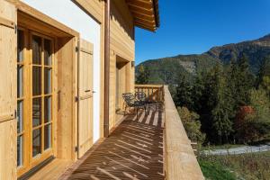 a wooden deck with a bench on the side of a building at Chalet Grand Roi in La Tzoumaz