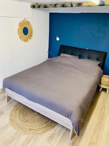 Jolie chambre indépendante في ليموج: غرفة نوم بسرير كبير بجدار ازرق