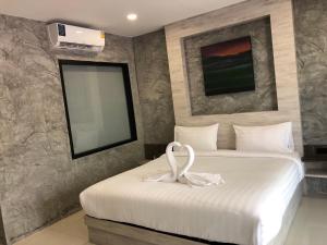 a hotel room with a bed with a swan on it at Dee Homestay in Ban Pa Khlok