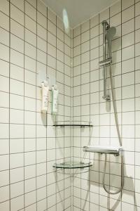 a white tiled bathroom with a shower and two sinks at The Connoisseur Residence Hotel in Seoul
