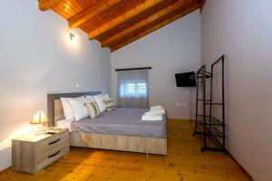 ein Schlafzimmer mit einem Bett und einem Fernseher in einem Zimmer in der Unterkunft Vitos Village House in Ágios Matthaíos