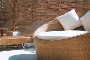 a patio with two wicker chairs and a pillow at My Island Home Gili Air in Gili Air
