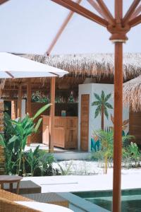 un complejo con piscina y techo de paja en My Island Home Gili Air en Gili Air