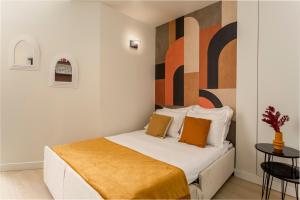 a bedroom with a bed with a large painting on the wall at Best Stay Jeuneurs in Paris