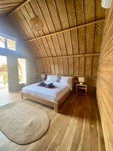 a bedroom with a bed with a wooden ceiling at My Island Home Gili Air in Gili Islands