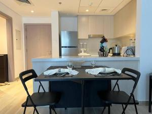 a kitchen with a table with two chairs with wine glasses at Best deal in town Yas Island 232WB10 in Abu Dhabi