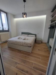 1 dormitorio con 1 cama y suelo de madera en Casa Camelia - appartamento in centro a Seregno, en Seregno