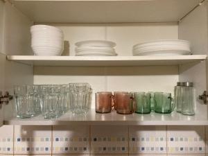 a shelf filled with glasses and plates and bowls at Pokoje do wynajęcia - Podwisłocze 8a in Rzeszów