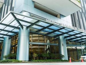 a large building with blue columns in front of it at Mercu Summer Suites KLCC by Veedu Hauz in Kuala Lumpur