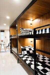 two bunk beds with checkered pillows in a room at J & J Homestay in Coron