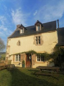 una vieja casa de piedra con una mesa de picnic delante de ella en Frairie Du Divit en Pontivy