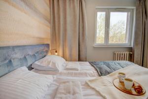 Un dormitorio con dos camas y una ventana. en HelApart - Rodzinny, en Hel
