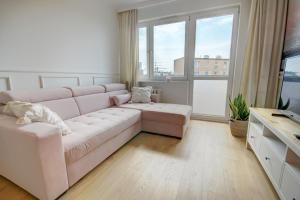 Una sala de estar con un sofá y una ventana grande. en HelApart - Rodzinny, en Hel