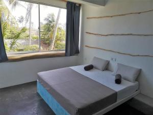 a bedroom with a bed with a large window at NAVA b&b in Mirissa