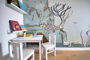 una mesa y sillas en una habitación con un mural en la pared en HelApart - Rodzinny, en Hel 28 fotos más