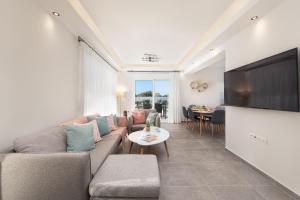 a living room with a couch and a flat screen tv at Villa Odysseas in Ialysos +27 photos
