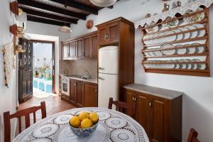 una cocina con una mesa con un bol de fruta. en Genovefa traditional house en Koskinou