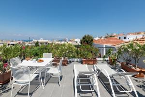 a patio with a white table and chairs on a roof at Genovefa traditional house in Koskinou