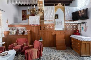 a room with chairs and a table and a tv at Genovefa traditional house in Koskinou