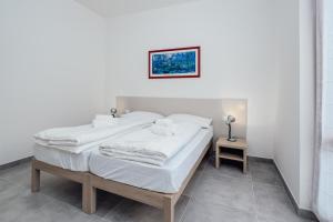 um quarto branco com 2 camas e uma mesa em Classic Bardolino Apartment em Bardolino