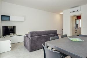 ein Wohnzimmer mit einem Tisch und einem Sofa in der Unterkunft Classic Bardolino Apartment in Bardolino