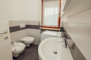 uma casa de banho com um lavatório branco e um WC. em Classic Bardolino Apartment em Bardolino