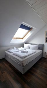 Cette chambre comprend un grand lit et une fenêtre. dans l'établissement Tulpenoase, à Neuendettelsau