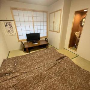 大阪的住宿－茶隐の宿，一间带大床和电视的卧室